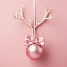Pink Christmas Ball With Reindeer Antlers On Pastel Rose Background. Minimal New Year Concept With Copy Space. Xmas Design For Banner And Greeting Card