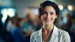 A female doctor or nurse is standing in the front row of a medical training class or seminar room background, smiling cheerfully and looking confident,