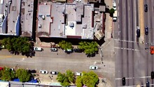 Aerial Top Shot Of Cars Moving On Road Amidst Buildings, Drone Panning During Sunny Day - Culver City, California