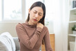 © KMPZZZ - Pain body muscles stiff problem, suffer asian young woman, girl face painful, hand holding neck ache from work hand holding massaging rubbing shoulder hurt, sore sitting on couch at home. Health care