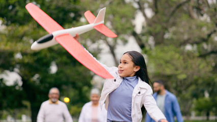 Poster - Outdoor, family and girl with an airplane, playing and child in park with parents for holiday, adventure and weekend outdoors with joy. Happy, group or kid with plane, mom or dad in nature with a toy