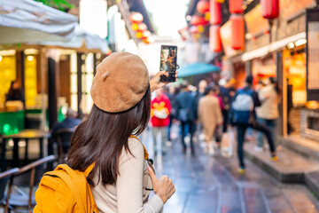 Young female tourist taking a photo of the Jinli Ancient Street in Chengdu, China