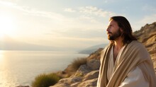 Jesus in robe standing on stone shore strewn with bushes by sea looking at landscape. Jesus Christ walking near sea. Jesus Christ calmly walking near sea searching for asks for important questions