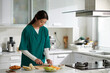 © DragonImages - Young woman working as medical nurse cooking breakfast in kitchen