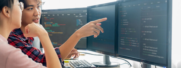 Cropped image of professional programer team collaboration discuss about web coding while coworker point java script displayed on computer at modern company office. Closeup. Burgeoning.