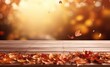 © Goojournoon - Autumn leaves are falling over an outdoor table.