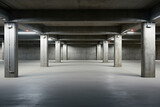 Fototapeta  - Front view of new empty underground parking with concrete columns, shiny asphalt, and nobody inside