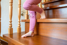 Closeup Of Little Child Girl Feet Going Down The Stairs At Home, Child Climbing Stairs
