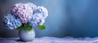© dashtik - hydrangea flowers in vase on light blue pastel background