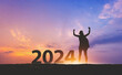 © Peera - New year 2024 traveler woman with sunset sky background travel concept