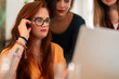 © Studio Marmellata - Positive female worker with crop multiracial colleagues in casual clothes gathered at table with laptop and smiling while looking at screen and working together in office