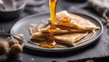 Honey Pouring On Crepes Or Blini, Black Background Closeup View.