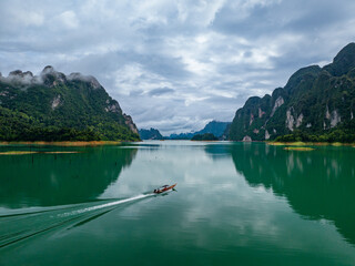 Wall Mural - Aerial drone view of tourist boat on the lake of tropical Mountain peak , Khao Sok National Park, Thailand