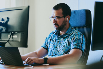 Wall Mural - Portrait professional man programmer working concentrated on computer in diverse offices. Modern IT technologies, development artificial intelligence, programs, applications and video games concept.