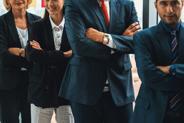 Wall Mural - Successful business people standing together showing strong relationship of worker community. A team of businessman and businesswoman expressing a strong group teamwork at the modern office. Jivy