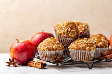 Wall Mural - Cinnamon streusel apple muffins or mini cakes on a baking tray. Homemade bakery. Fresh red apples. Healthy breakfast. Beige background.