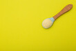 Dairy-free wheat porridge with pumpkin in a spoon on a yellow background. The concept of feeding a baby vitamin-mineral cereals for health and strengthening the immune system. Copy space for text