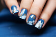 Christmas manicure on women's hands with blue and white colors and with holiday design