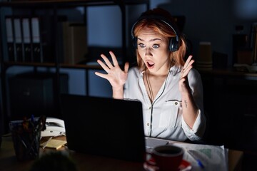 Canvas Print - Young caucasian woman working at the office at night celebrating crazy and amazed for success with arms raised and open eyes screaming excited. winner concept