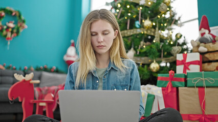 Sticker - Young blonde woman using laptop celebrating christmas at home