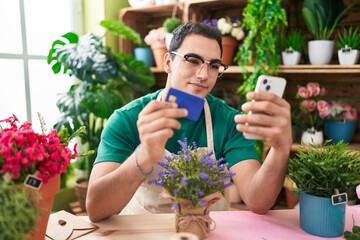 Sticker - Young hispanic man florist using smartphone holding credit card at flower shop