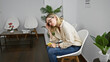 © Krakenimages.com - Young blonde woman business worker using smartphone looking upset at the office waiting room