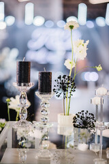 Wall Mural - Black and white candle. Trendy rich decor. Luxury wedding reception. Banquet decoration composition flowers, candlesticks in hall restaurant. Table setting, setup. Birthday, event. Details interior.