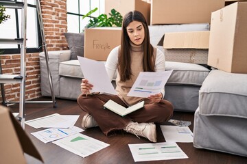 Sticker - Young beautiful hispanic woman reading document sitting on floor at new home