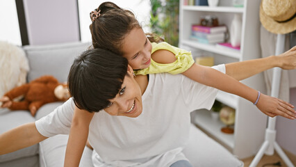 Sticker - Confident mother and happy daughter, sitting back on the living room sofa, playing a game of indoor flight, their joyful expressions turn the house into a flying plane, their love just soaring!