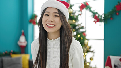 Poster - Young chinese woman celebrating christmas smiling at home