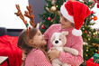 © Krakenimages.com - Brother and sister hugging each other standing by christmas gifts at home