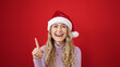 © Krakenimages.com - Young blonde woman wearing christmas hat with idea expression over isolated red background