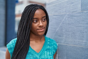 Wall Mural - African american woman standing with relaxed expression at street