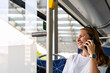 Woman talks on the phone while traveling on a public bus.