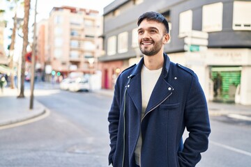 Canvas Print - Young hispanic man smiling confident looking to the side at street