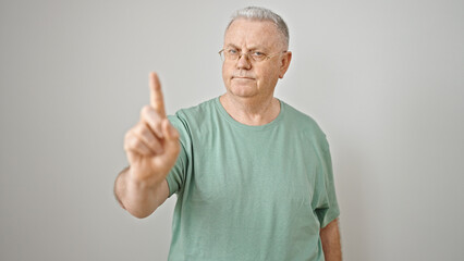 Middle age grey-haired man standing with serious expression saying no with finger over isolated white background