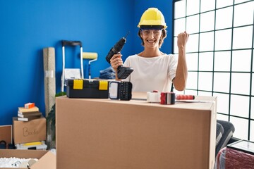 Poster - Brunette woman holding screwdriver at new home screaming proud, celebrating victory and success very excited with raised arms