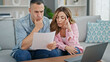 © Krakenimages.com - Man and woman couple using laptop reading document at home