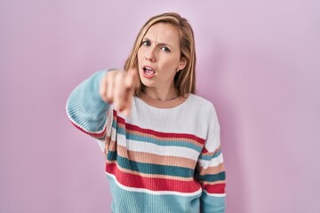 Poster - Young blonde woman standing over pink background pointing displeased and frustrated to the camera, angry and furious with you