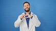 © Krakenimages.com - Young hispanic man doctor smiling doing heart gesture with hands over isolated blue background