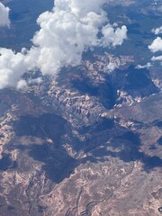 Sticker - Vertical aerial view of a rural landscape enveloped in puffy clouds in sunlight