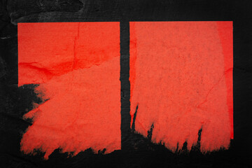 Scraps of two red posters on a black background.