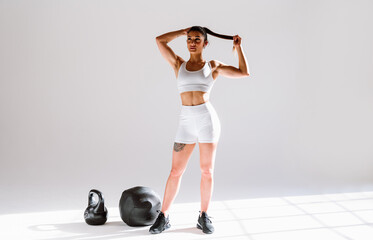 Poster - Young female athlete training in a gym using sport equipment. Fit woman working out . Concept about fitness, wellness and sport preparation.