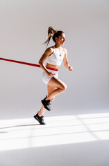 Wall Mural - Young female athlete training in a gym using sport equipment. Fit woman working out . Concept about fitness, wellness and sport preparation.