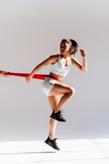 Wall Mural - Young female athlete training in a gym using sport equipment. Fit woman working out . Concept about fitness, wellness and sport preparation.