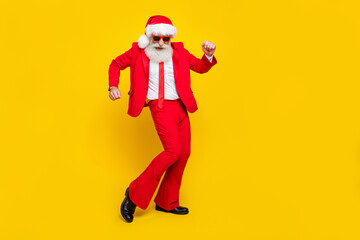 Wall Mural - Full length photo of cheerful positive retired guy wear red tux claus hat dancing empty space isolated yellow color background