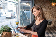 © MelisaCabal - A 45-Year-Old Woman Working on Her Laptop in a Stylish Café.