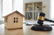 © Studio Romantic - Closeup wooden toy house and close up judge's gavel on table with scales of justice in courtroom or lawyer's office. Legal services, real estate, property law concept