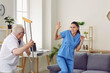 © Studio Romantic - Senior patient showing aggression toward medical worker. Old man wakes up in bad mood, starts fight with hospital staff, threatens nurse with crutch and gets very angry, dangerous and uncontrollable