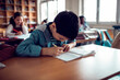 © Marko Geber - Little boy taking notes in classroom